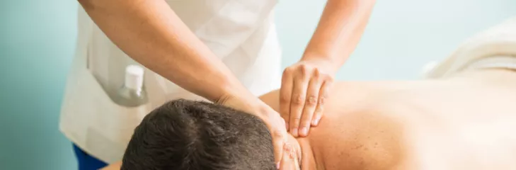 Ayurvedic therapist massaging the neck of a male patient