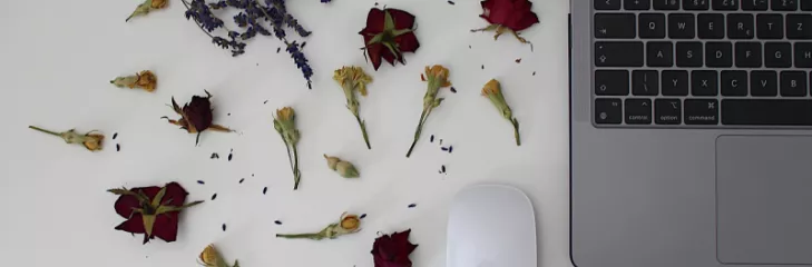 laptop on desk with scattered flowers