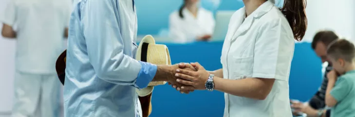 Nurse shaking hand with an elderly person